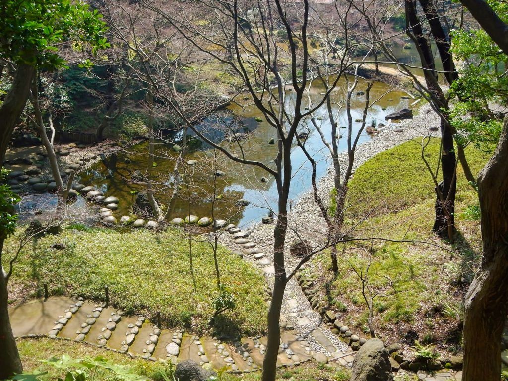 Puente de piedras para cruzar el lago Jardines Koishikawa Korakuen de Tokio